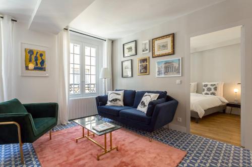 ein Wohnzimmer mit einem blauen Sofa und einem Bett in der Unterkunft Strada - magnifique appartement proche Opéra in Lyon