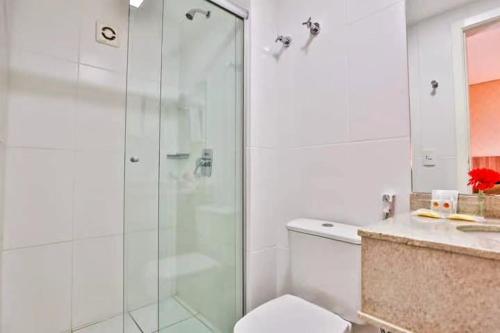y baño con ducha de cristal y aseo. en Flat Particular - próx Assembleia Leg MT, en Cuiabá