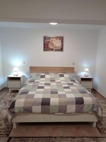 a bedroom with a bed with two nightstands and two tables at Trikala Alex House in Tríkala