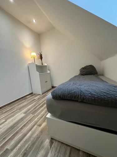 a white room with a bed and a night stand at Schöne, moderne Wohnung mit Waldblick & Parkplatz in Melle
