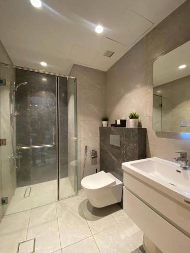 a bathroom with a shower and a toilet and a sink at Unique Apart Boulevard Damac Tc2 in Ash Shumaysānī