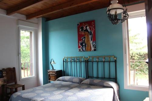 a bedroom with a blue wall with a bed at El Rincon del Tejo in Herreros