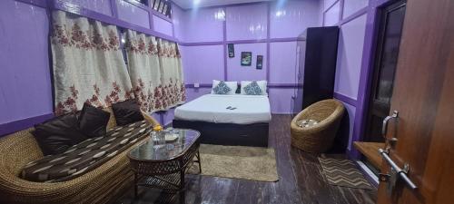 um quarto roxo com uma cama e um sofá em Bloom inn em Shillong