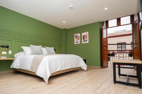 a bedroom with green walls and a large bed at Siete Balcones Hotel Coworking in Pasto