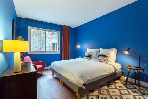 a blue bedroom with a bed and a chair at Stella - 2 chambres-balcon- place de la République in Lyon