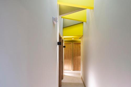 a hallway with a yellow ceiling and a white wall at Siete Balcones Hotel Coworking in Pasto
