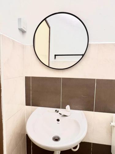 a bathroom with a white sink and a mirror at Hey90s #6pax #FreeNetflix #Youtube #Games in Kluang
