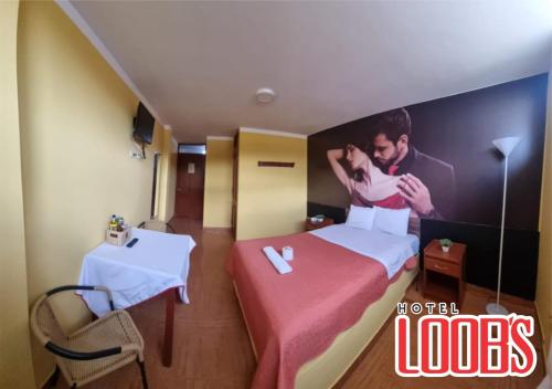 una habitación de hotel con un cartel de un hombre y una mujer en hotel loob's, en Los Baños del Inca
