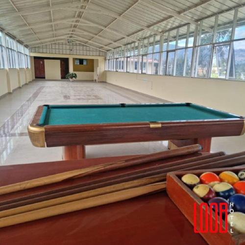 hotel loob's في Los Baños del Inca: طاولة بلياردو في غرفة كبيرة مع حمام سباحة