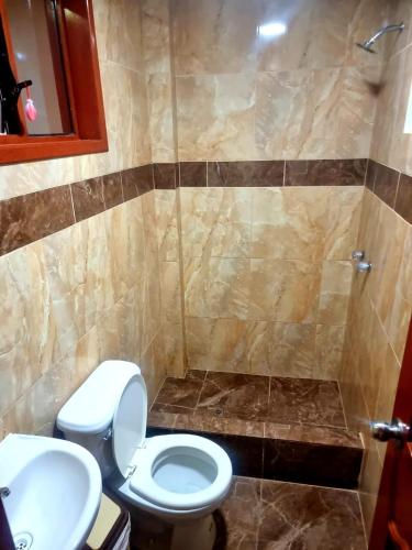 uma casa de banho com um WC e um chuveiro em hotel loob's em Los Baños del Inca