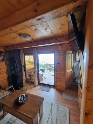 ein Wohnzimmer mit einem Tisch und einem großen Fenster in der Unterkunft Livari Rooms Exclusive Chalet in Bar
