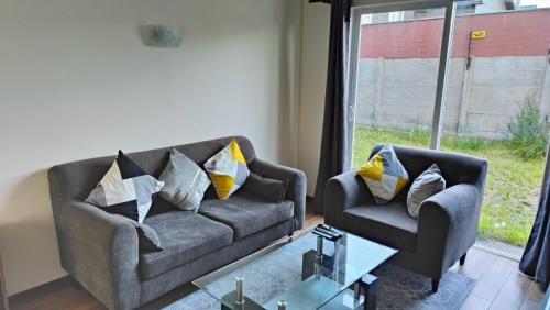 uma sala de estar com um sofá e uma cadeira em Casa en sector Las Mariposas em Temuco