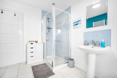 a white bathroom with a shower and a sink at The Home on The Hill in Birmingham