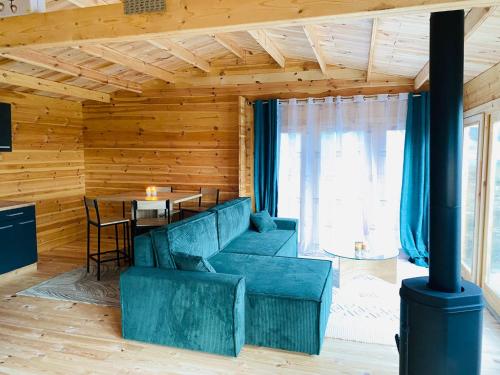 a living room with a blue couch and a table at CHALET EN BOIS PRIVATIF ST POURCAIN SUR SIOULE in Bransat