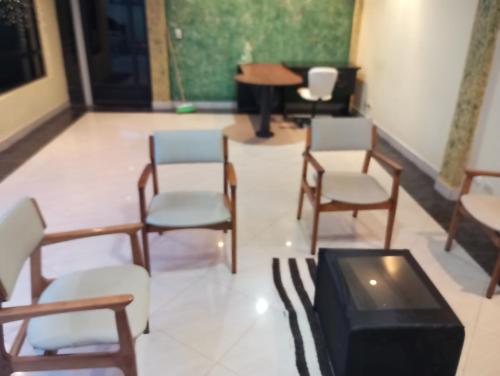 ロハにあるSuite amplia y eleganteの椅子、テーブル、ピアノ付きの部屋