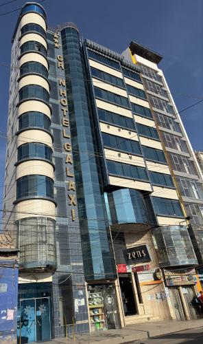 een hoog gebouw met glazen ramen aan een straat bij Hotel V I D GALAX Resort in Oruro