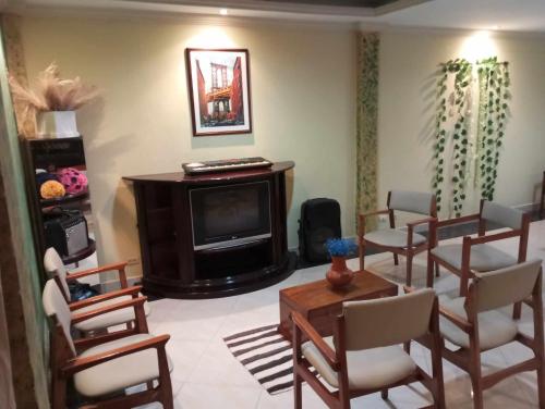 a living room with chairs and a television at Suite amplia y elegante in Loja
