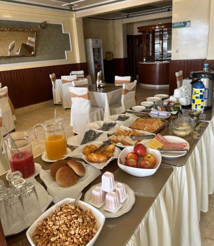 een lange tafel met veel verschillende soorten voedsel erop bij Hotel V I D GALAX Resort in Oruro