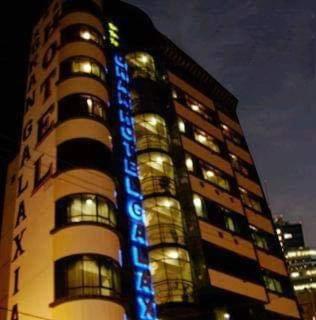 een hoog gebouw met een blauw bord erop bij Hotel V I D GALAX Resort in Oruro