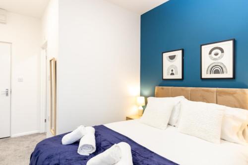 a bedroom with a blue accent wall and a bed at Suite 4 - Trendy Spot in Oldham City Centre in Oldham