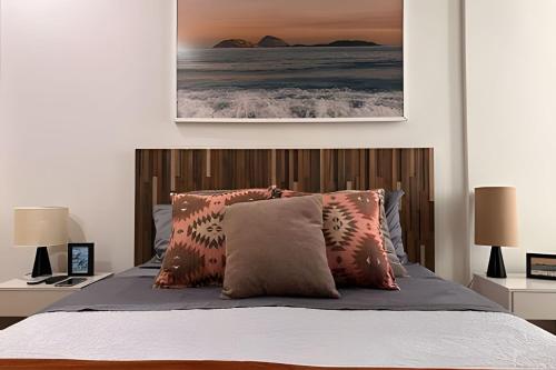a bedroom with a bed with a wooden headboard at Apto Luxuoso, 50 Mts da Praia em Copacabana para 6 in Rio de Janeiro