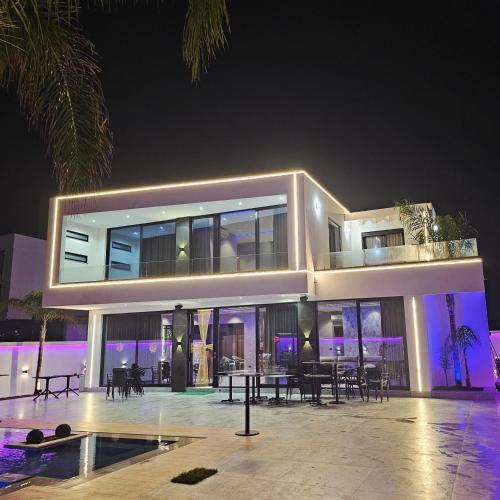 a large house at night with tables and chairs at Alfa Villa in Rrushkull