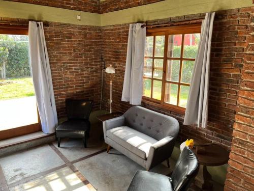 a living room with a couch and two chairs at Hermoso quincho a pasos del mar in Playa Verde