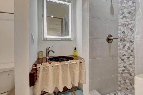 a bathroom with a sink and a shower with towels at Garden Beach studio @The Island in Deerfield Beach