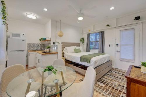 a bedroom with a bed and a table and a kitchen at Garden Beach studio @The Island in Deerfield Beach