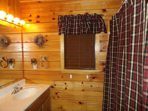 a bathroom with a sink and a shower in a cabin at Beary Tale! Your happily ever after starts here! in Sevierville