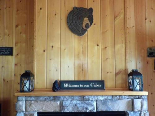 a wooden wall with a bear head on top of a fireplace at Beary Tale! Your happily ever after starts here! in Sevierville