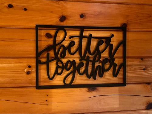 a sign on a wooden wall with the word better execution at Beary Tale! Your happily ever after starts here! in Sevierville