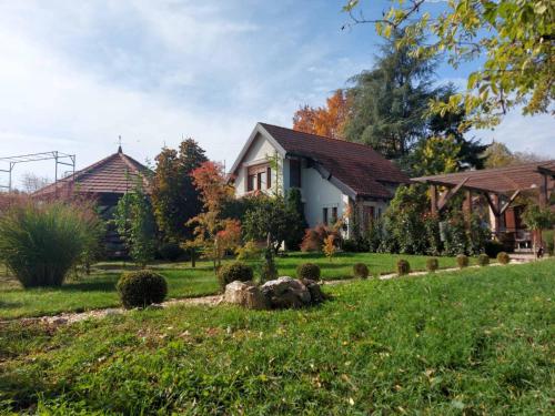 ein Haus in einem Garten mit grünem Rasen in der Unterkunft Kuca na Savi - Stari hrast in Vladimirci
