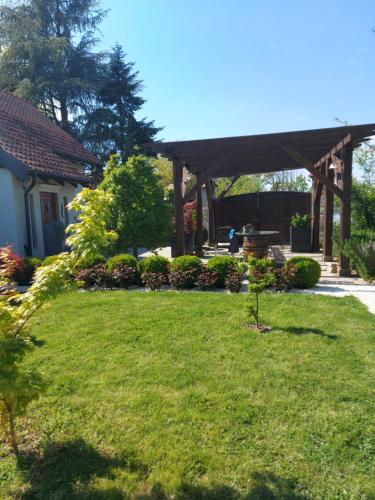 einen Garten mit einer hölzernen Pergola im Hof in der Unterkunft Kuca na Savi - Stari hrast in Vladimirci
