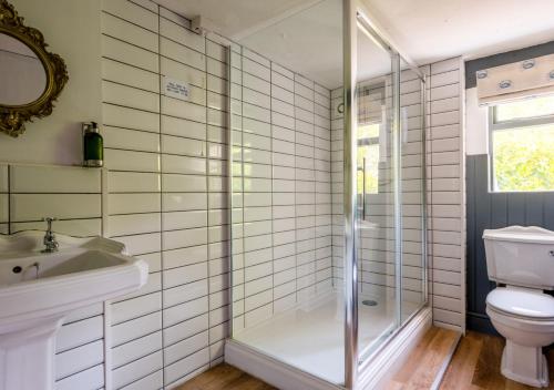 uma casa de banho com um chuveiro, um WC e um lavatório. em Church Farm em Halesworth