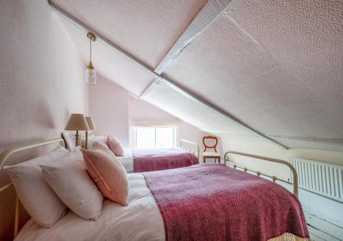 1 dormitorio con 2 camas en un ático en Church Farm, en Halesworth