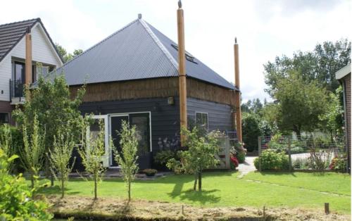 a house with a gambrel roof at Romantisch Vakantiehuis de Hooiberg in Berkenwoude