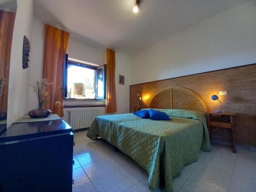 a bedroom with a bed and a desk and a window at Menhir in Tempio Pausania