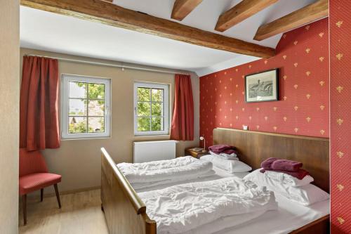 a bedroom with two beds and a red wall at Landhaus Kaiserpfalz #2 bis 10P in Memleben