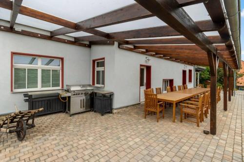 a patio with a table and chairs and a kitchen at Landhaus Kaiserpfalz #2 bis 10P in Memleben