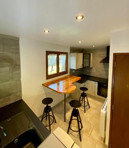 - une cuisine avec une table et des tabourets dans l'établissement Le Refuge de l'Indien Couché, à La Roche-des-Arnauds