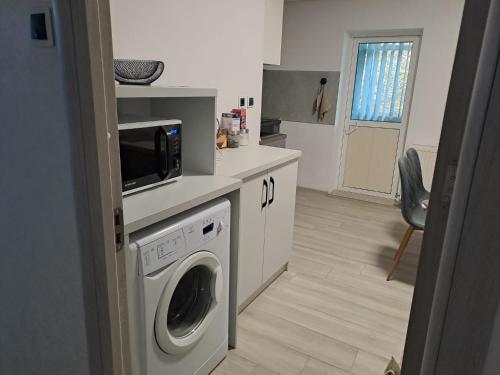uma cozinha com uma máquina de lavar roupa e um micro-ondas em ILONA APARTAMENT 3 camere em Râmnicu Vâlcea
