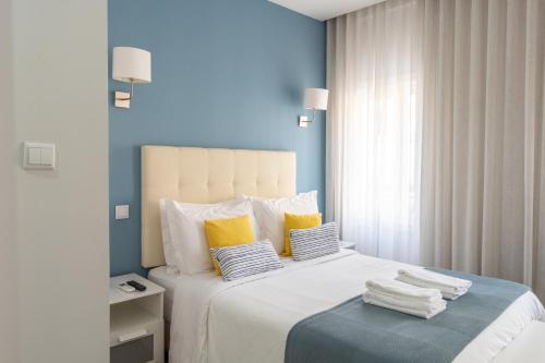 1 dormitorio con 1 cama blanca grande con almohadas amarillas en Bella Gaia - Alojamento Local, en Vila Nova de Gaia