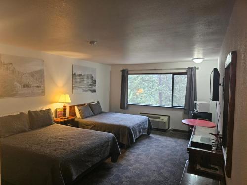 une chambre d'hôtel avec deux lits et un canapé dans l'établissement Rimrock Lodge LLC, à Thompson Falls