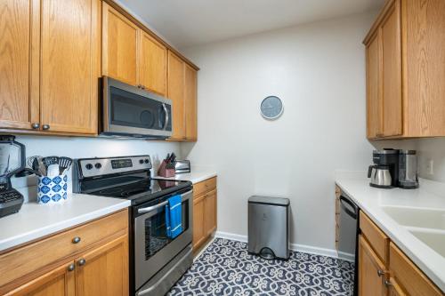 a kitchen with wooden cabinets and a stove top oven at Near Pool*Balcony*VistaCay Convention Ctr & Idrive in Orlando