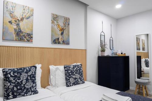um quarto com uma cama branca e pinturas na parede em Bella Gaia - Alojamento Local em Vila Nova de Gaia