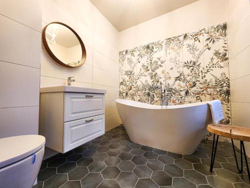 a bathroom with a tub and a toilet and a sink at Apartmány Rangifer in Plzeň