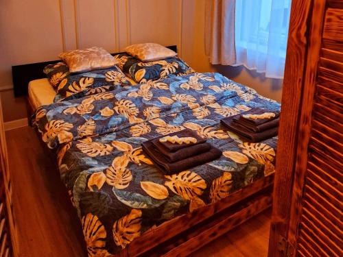 a bed with a blue comforter with towels on it at Apartamenty Toskania No.4 Jacuzzi & Sauna in Poznań