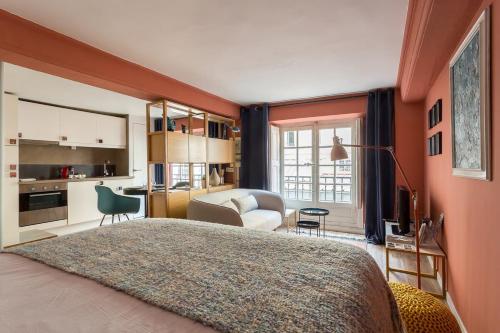 a bedroom with a large bed and a living room at Sainte Hélène - Location studio - Lyon 2 in Lyon