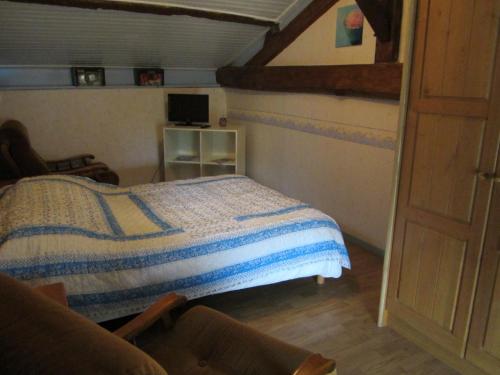 a bedroom with a bed with a blue and white blanket at Chambres, Table d'Hôtes et Gites Les Mesanges in Saint-Jean-de-Sauves